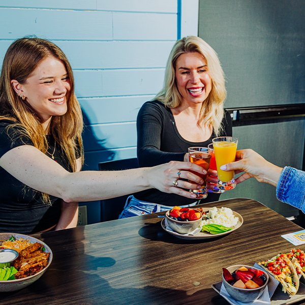 three girls drinking mimosas together